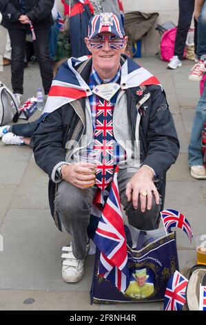 Ein Mann mit Union Jack, Brille, Krawatte und Hut, der Teil einer großen Menschenmenge war, traf sich auf dem Trafalgar Square, um einen riesigen Fernseher zu sehen, der ihre königliche Hoheit, Königin Elizabeth ii, die Feierlichkeiten zum Diamantenjubiläum zeigte. Trafalgar Square, London, Großbritannien. 5 Juni 2012 Stockfoto