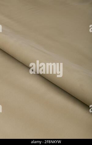 Farbiger brauner Textil-Satinstoff in Falten und Wellen gefaltet Mit Highlights und Textur schimmert im Licht Stockfoto