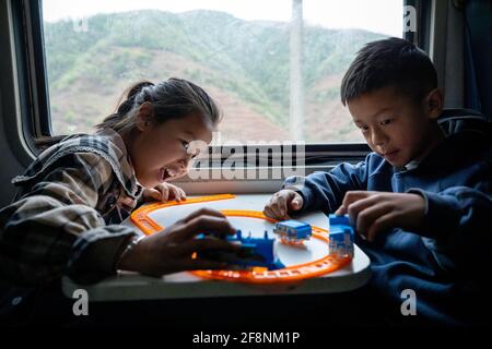 (210415) -- XICHANG, 15. April 2021 (Xinhua) -- Schüler nehmen den Zug 5633 zur Schule in der südwestlichen chinesischen Provinz Sichuan, 11. April 2021. Während moderne Hochgeschwindigkeitszüge an neuen Bahnhöfen in ganz China vorbeifahren, fahren noch immer zwei langsamere Züge durch die Daliang Mountains. Die 5633/5634 Züge verkehren zwischen Puxiong und Panzhihua in der Provinz Sichuan mit einer Durchschnittsgeschwindigkeit von weniger als 40 km pro Stunde. Die Fahrt mit 26 Stationen dazwischen dauert elf Stunden und vier Minuten, die Fahrkartenpreise reichen von 2 Yuan bis 25.5 Yuan (etwa 0.3-3.9 US-Dollar). Die langsamen Züge senden kindr Stockfoto