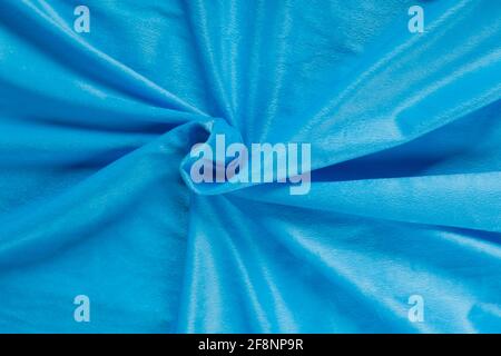 Farbiger blauer Textil-Satin-Stoff in Falten und Wellen gefaltet Mit Highlights und Textur schimmert im Licht Stockfoto
