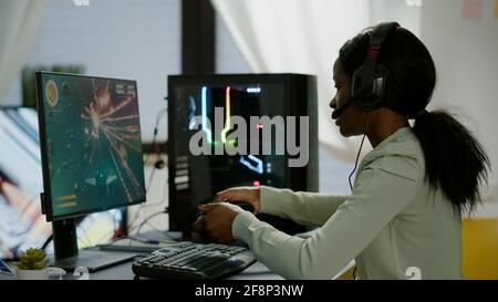 Upsed african Frau Gamer Streaming Online-Videospiele und verlieren spielen auf RGB leistungsstarke Computer mit Wireless-Controller. Spieler mit Kopfhörern, der den Sieg im Spielezimmer feiert Stockfoto