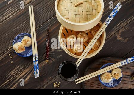 Shumai Shaomai Chinesisches Fleischknödel gedünstetes Gericht in Bambus-Dampfgarer-Box. Essstäbchen und Dimmen. Stockfoto