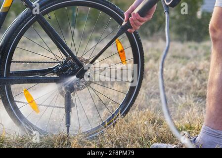 Fahrradwäsche auf dem Hinterhof. Frühlingsvorbereitungen für die Radsaison. DIY Bike Pflege, Druck Fahrrad waschen Stockfoto