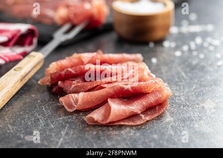 In Scheiben geschnittener Carpacio. Rohes Rindfleisch auf schwarzem Tisch. Stockfoto