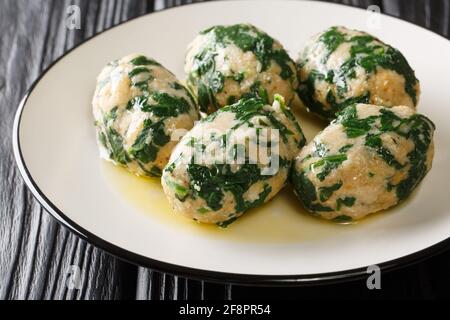 Strangolapreti, italienische Gnocchi aus Brot und Spinat in Nahaufnahme auf einem Teller auf dem Tisch. Horizontal Stockfoto