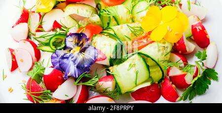 Frühlingssalat mit Gemüse und essbaren Blumen.Diät-Konzept.Bunte Lebensmittel Stockfoto