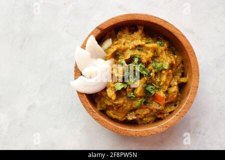 Baigan Bharta, auch Vangyache Bharit in Marathi genannt. Es handelt sich um ein geröstetes Auberginen-getrocknetes. Brinjaler Chutney. Serviert in einer Holzschale mit Roti. Stockfoto