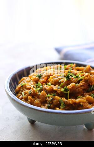 Baigan Bharta, auch Vangyache Bharit in Marathi genannt. Es handelt sich um ein geröstetes Auberginen-getrocknetes. Brinjaler Chutney. Serviert in einer Holzschale mit Roti. Stockfoto