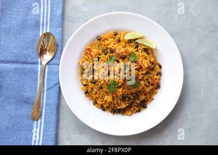 Indische Küche - Kichererbsen Biryani, chole Pulao. Garniert mit gebratener Zwiebel, gehacktem Koriander und Zitronenkeilen. Kala chana biryani. Raum kopieren Stockfoto