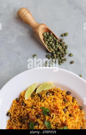 Indische Küche - Kichererbsen Biryani, chole Pulao. Garniert mit gebratener Zwiebel, gehacktem Koriander und Zitronenkeilen. Kala chana biryani. Raum kopieren Stockfoto