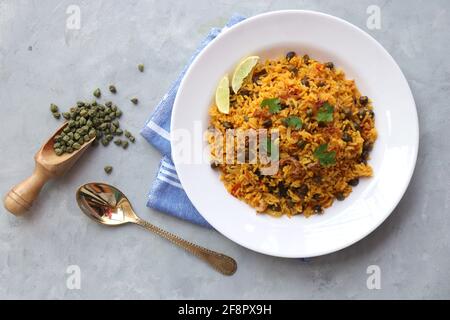 Indische Küche - Kichererbsen Biryani, chole Pulao. Garniert mit gebratener Zwiebel, gehacktem Koriander und Zitronenkeilen. Kala chana biryani. Raum kopieren Stockfoto