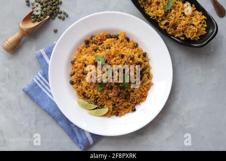 Indische Küche - Kichererbsen Biryani, chole Pulao. Garniert mit gebratener Zwiebel, gehacktem Koriander und Zitronenkeilen. Kala chana biryani. Raum kopieren Stockfoto