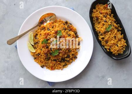 Indische Küche - Kichererbsen Biryani, chole Pulao. Garniert mit gebratener Zwiebel, gehacktem Koriander und Zitronenkeilen. Kala chana biryani. Raum kopieren Stockfoto