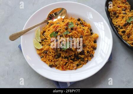 Indische Küche - Kichererbsen Biryani, chole Pulao. Garniert mit gebratener Zwiebel, gehacktem Koriander und Zitronenkeilen. Kala chana biryani. Raum kopieren Stockfoto