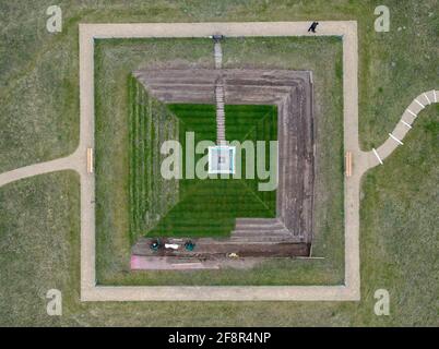 15. April 2021, Brandenburg, Branitz: Mitarbeiter des Fürst-Pückler-Museumsparks und der Stiftung Schloss Branitz arbeiten an den Stufen der historischen Landpyramide im Branitz-Park in Cottbus (Luftaufnahme mit Drohne). Die Landpyramide im Branitz Park hält derzeit ihre historischen Erdstufen auf allen vier Seiten zurück. Mit dieser herausfordernden Arbeit leisten die Parkgärtner aus eigener Kraft einen ganz besonderen Geschenkbeitrag zum 175. Jubiläum der Branitzer Parklandschaft. Ende April 2021 bestand die Arbeit aus Erdmodellierung und Verlegung von Rollrasen Stockfoto