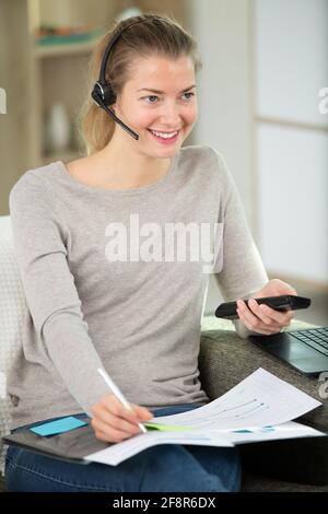 Freiberuflicher Mitarbeiter, der mit Headsets spricht Stockfoto