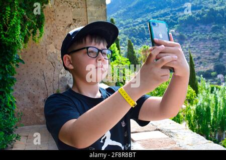 Schuljunge, der mit seinem iphone Fotos macht, Stockfoto