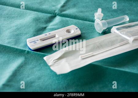 COVID-19 Rapid Antigen Test-Kit auf grünem OP-Gewebe-Hintergrund, gebrauchsfertig. Konzept einer umfassenden Teststrategie zur Bekämpfung der Pandemie. Stockfoto