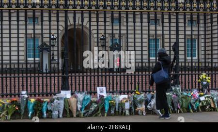 Ein Trauermann vor dem Buckingham Palace blickt auf die Blumengebete an Prinz Philip, den Herzog von Edinburgh. Stockfoto