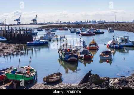 Ein Blick von Paddys Hole, Redcar, England, Großbritannien, zeigt die festgestemmten Boote und den industriellen Hintergrund von Teesport Stockfoto