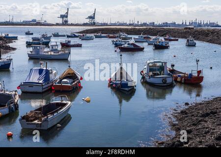 Ein Blick von Paddys Hole, Redcar, England, Großbritannien, zeigt die festgestemmten Boote und den industriellen Hintergrund von Teesport Stockfoto