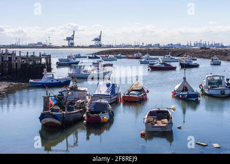 Ein Blick von Paddys Hole, Redcar, England, Großbritannien, zeigt die festgestemmten Boote und den industriellen Hintergrund von Teesport Stockfoto