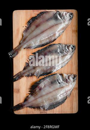 Roher Flunder Fisch, Meeresfrüchte auf einem hölzernen Schneidbrett . Gesunde Ernährung Konzept. Draufsicht Stockfoto