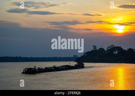 Barge, die bei Sonnenuntergang Kisangani ablegt und den Kongo entlang nach Kinshasa fährt. Demokratische Republik Kongo, Zentralafrika. Stockfoto