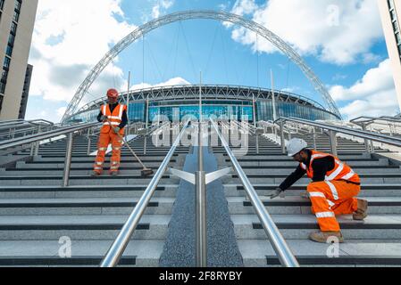 London, Großbritannien. 15. April 2021. Bauarbeiter auf der bald fertiggestellten olympischen Treppe im Wembley-Stadion. Die 48 Olympic Steps umfasst 4 Flüge zu je 12 Steps und wird das neue Tor zum Stadion für Besucher und Fans, die vom Olympic Way ankommen, und soll im Juni 2021 rechtzeitig für die Gruppenspiele der englischen Gruppe bei der Euro 2020 fertiggestellt werden. Kredit: Stephen Chung / Alamy Live Nachrichten Stockfoto