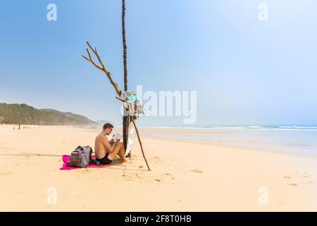 Schöner Mann am Strand von Quan Lan - Bai Bien - Insel, Bai TU Long Bay, Vietnam. Landschaftsfoto am Meer, aufgenommen in Südostasien, Ha Long-Gebiet. Stockfoto