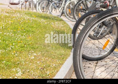 Detail der Fahrrad-Räder an einem reservierten Platz in geparkt Die Stadt für Bürger in der Nähe der Geschäfte mit Kopierplatz Und selektive Konzentration auf einen sonnigen Tag Stockfoto
