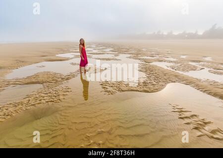 Schöne Frau am Strand von Quan Lan - Bai Bien - Insel, Bai TU Long Bay, Vietnam. Landschaftsfoto am Meer mit Nebel, aufgenommen in Südostasien, Ha Long-Gebiet Stockfoto