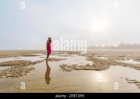 Schöne Frau am Strand von Quan Lan - Bai Bien - Insel, Bai TU Long Bay, Vietnam. Landschaftsfoto am Meer mit Nebel, aufgenommen in Südostasien, Ha Long-Gebiet Stockfoto