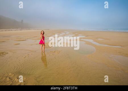 Schöne Frau am Strand von Quan Lan - Bai Bien - Insel, Bai TU Long Bay, Vietnam. Landschaftsfoto am Meer mit Nebel, aufgenommen in Südostasien, Ha Long-Gebiet Stockfoto