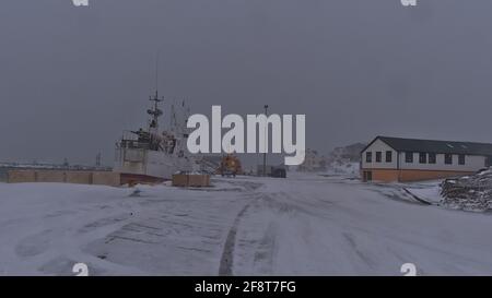 Blick auf den Hafen des kleinen Fischerdorfes Höfn an der Südküste Islands bei stürmischem Wetter in der Wintersaison mit gebundenem Schiff und Bau. Stockfoto