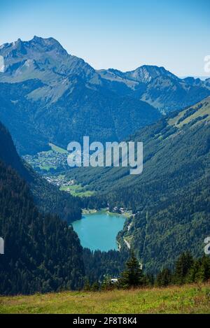 Schöne alpine Berglandschaft mit Montriond See und Dorfhäusern in den französischen Alpen, Morzine, Haute-Savoie, Frankreich. Landschaftlich reizvolle Natur Stockfoto