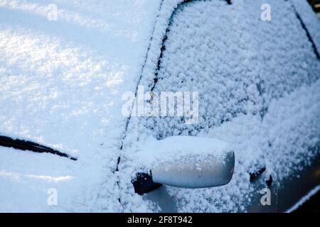 Nahaufnahme eines mit Schnee bedeckten Autofensters und Spiegels Stockfoto