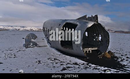 Berühmtes Flugzeugwrack eines DC-3 (C-117)-Flugzeugs am Strand von Solheimasandur an der Südküste im Winter mit spärlicher, schneebedeckter Landschaft. Stockfoto