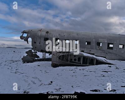 Seitenansicht des einsamen Flugzeugwracks eines DC-3 (C-117) Flugzeugs am Solheimasandur Strand an der Südküste in der Wintersaison mit spärlicher Landschaft. Stockfoto