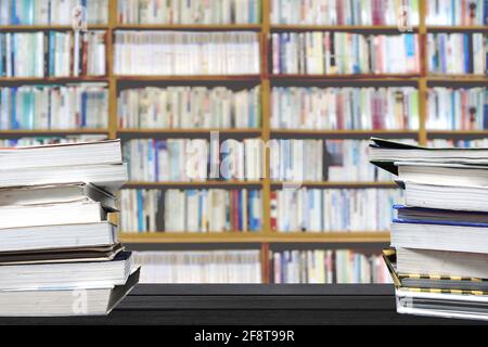 Bücher stapelten sich auf dem Bibliothekstisch Stockfoto