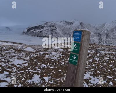 Holzschild neben Wanderweg im Vatnajökull Nationalpark in der Wintersaison führt zum Kristínartindar Berg mit Gletscher Skaftafellsjökull. Stockfoto