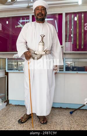 Älterer omanischer Mann, der den traditionellen Khanjar in der Stadt Ibra, Oman trägt. Stockfoto