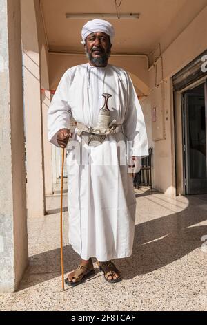 Älterer omanischer Mann, der den traditionellen Khanjar in der Stadt Ibra, Oman trägt. Stockfoto