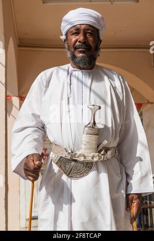 Älterer omanischer Mann, der den traditionellen Khanjar in der Stadt Ibra, Oman trägt. Stockfoto