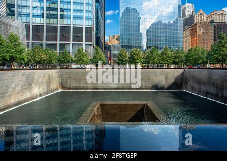 Im Norden einen reflektierenden Pool bei Dämmerung mit Blick auf das World Trade Center Tower 3 und 4 und die Oculus beleuchtet. Lower Manhattan, New York City