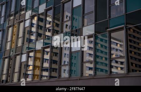 Berlin, Deutschland. April 2021. Apartmentgebäude spiegeln sich in einer Glasfassade wider. Das Bundesverfassungsgericht hat die Mieterobergrenze, die 2020 in zwei Stufen in Kraft getreten ist, in einer am Donnerstag veröffentlichten Entscheidung für nichtig erklärt. Quelle: Paul Zinken/dpa-Zentralbild/dpa/Alamy Live News Stockfoto