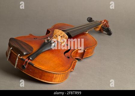 Deutschland. April 2021. Eine alte Geige mit leichten Kratzern und Beschädigungen, die auf einem neutralen, grauen Hintergrund liegt. Credit: dpa/Alamy Live News Stockfoto