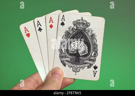 Deutschland. April 2021. Spielkarten aus einem alten Kartenspiel, dem Französischen Blatt, mit vier Assen, die von einer Hand in einem Bluten vor grünem Hintergrund gehalten werden. Credit: dpa/Alamy Live News Stockfoto