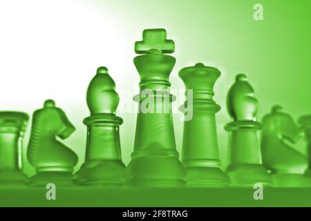 Deutschland. April 2021. Symbolische Schachfiguren eines Schachspiels aus Glas mit neutralem Hintergrund. Detail einiger weißer Figuren mit einer grünen Lichtstimmung aus der Perspektive eines leichten Frosches. Credit: dpa/Alamy Live News Stockfoto