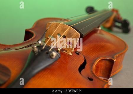 Deutschland. April 2021. Eine alte Geige mit leichten Kratzern und Schäden im Bluten auf neutralem, grünem Hintergrund. Credit: dpa/Alamy Live News Stockfoto